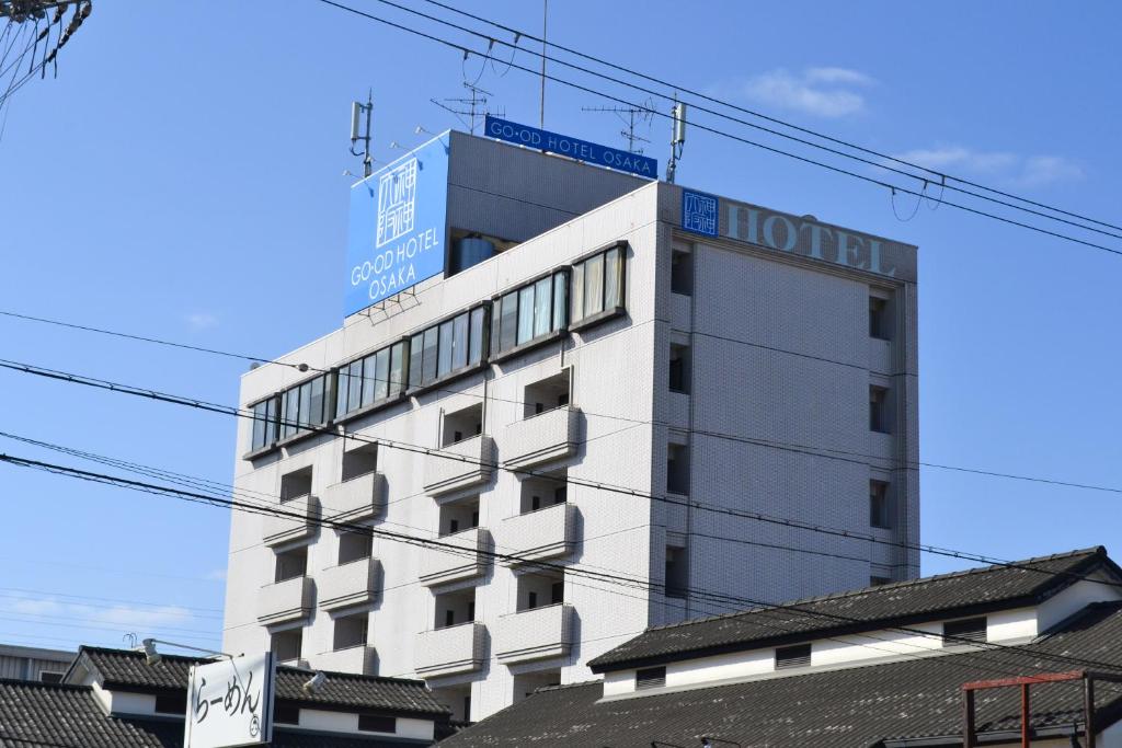a white building with a sign on top of it at Good Hotel Osaka in Toyonaka