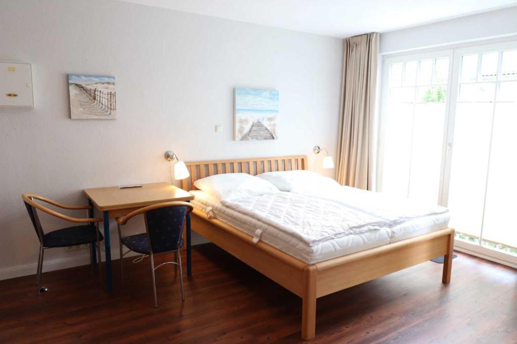 um quarto com uma cama, uma secretária e uma mesa em Strandstraße 32 - 04-43 em Kühlungsborn