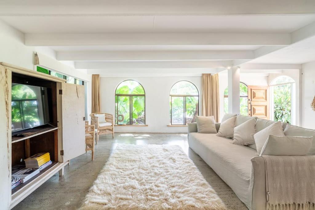 a living room with a white couch and a tv at Studio Birdsong in East Ballina