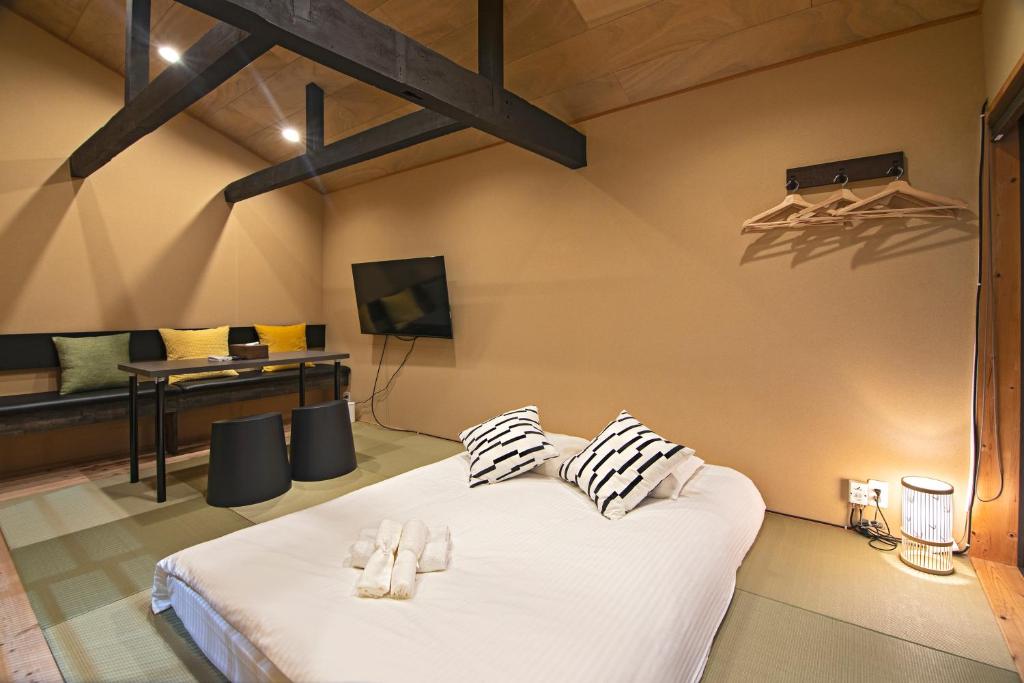 a bedroom with a large white bed with two pillows at -時の宿 上七軒- Kyoto Machiya 金閣寺周辺 in Kyoto
