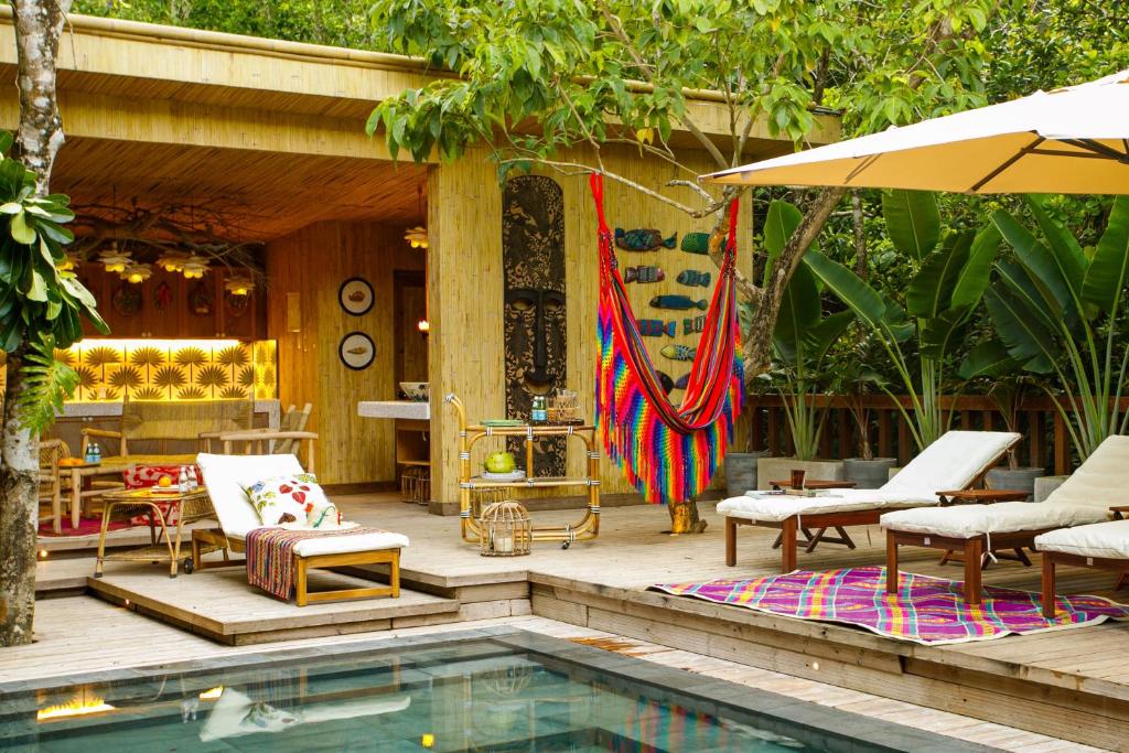 um pátio com uma piscina, cadeiras e um guarda-sol em Bahay Artisano em El Nido
