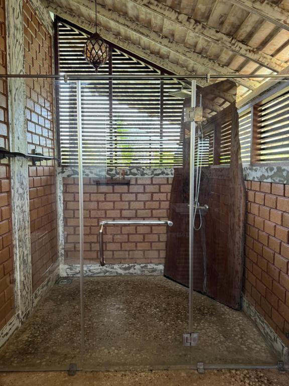 an empty room with a shower in a brick wall at OHEI in Tangalle
