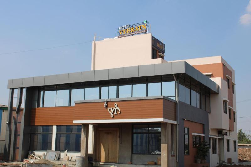 a building with a sign on top of it at Hotel Veeratn in Kolhapur