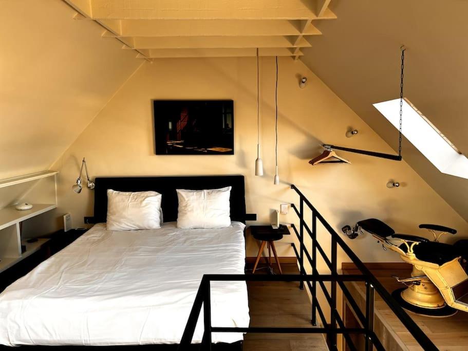 sypialnia z białym łóżkiem na poddaszu w obiekcie Agelandkaai (.be) Free Parking w Gandawie