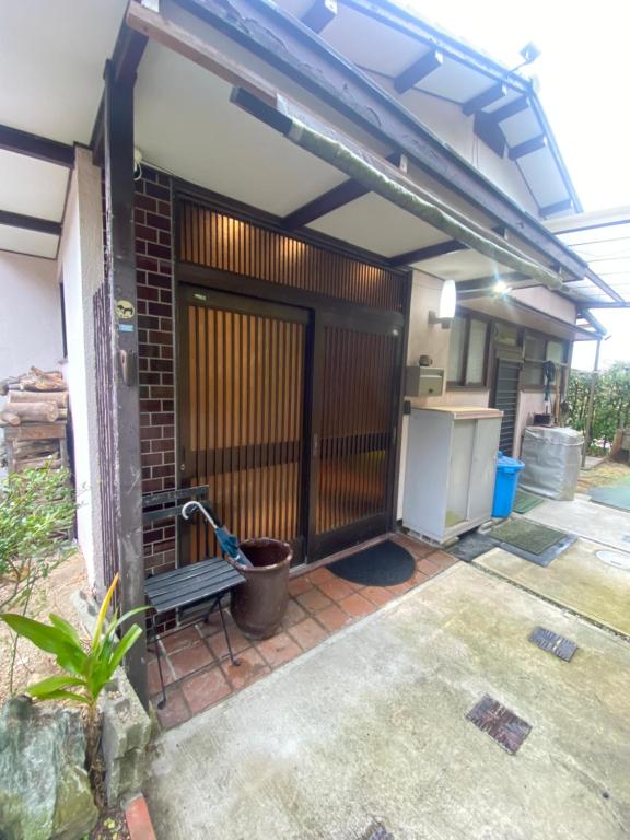 un garage avec un portail et un mur en briques dans l'établissement Naoshima J-House, à Naoshima