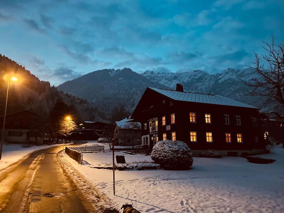 a house in the snow next to a street at Hüttenzauber Ferienwohnung in Vandans