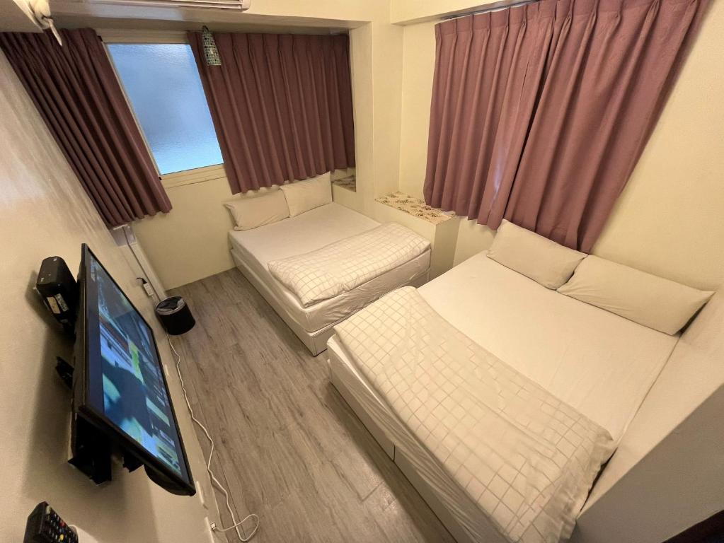 台中的住宿－逢甲Inn好窩，小房间设有两张床和一台平面电视