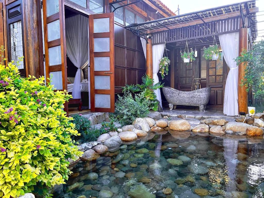 a garden with a pond in front of a house at Zen House Hoi An - Wooden House in Hoi An