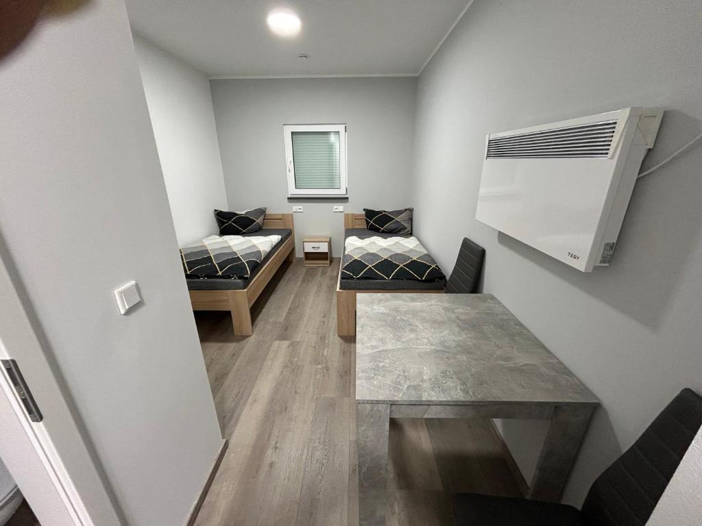 a small room with two beds and a table at La Maria Aparts in Mardorf