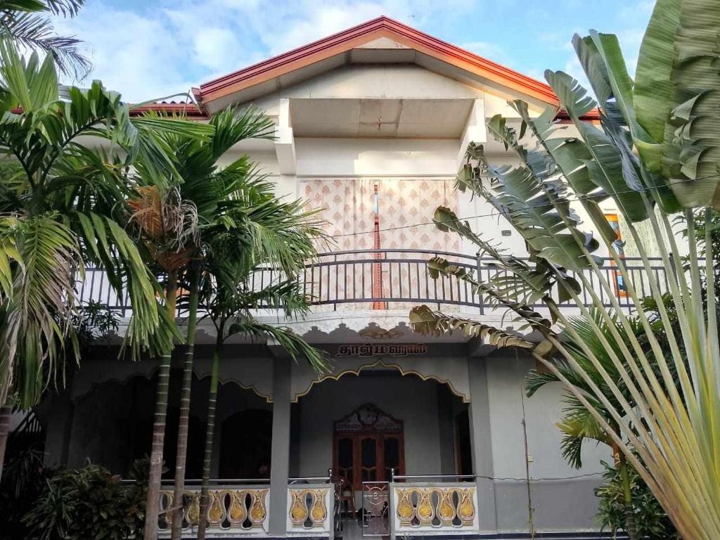 une maison avec des palmiers devant elle dans l'établissement Villa Chava, à Chavakachcheri