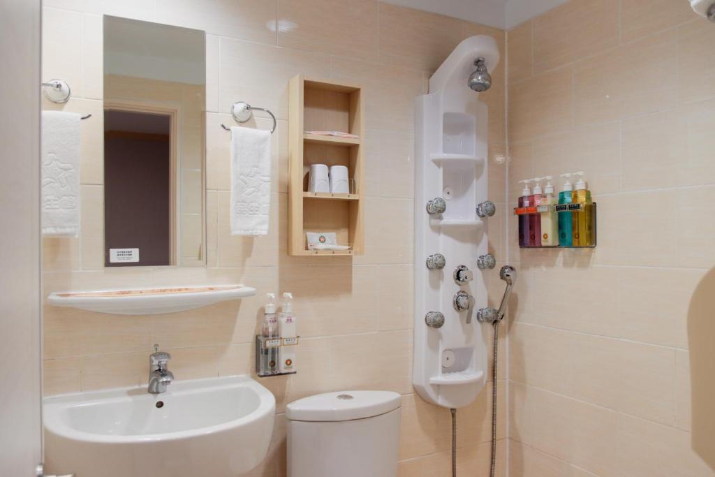 a bathroom with a sink and a toilet and a shower at Kindness Hotel - Tainan Minsheng in Tainan