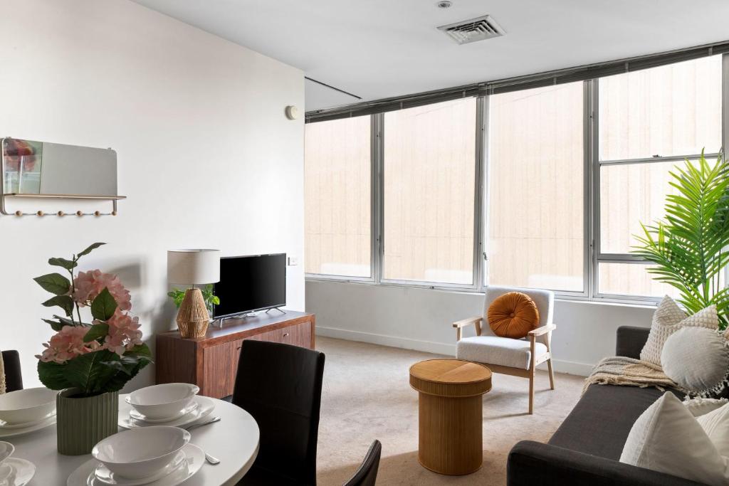 a living room with a couch and a table at A Stylish & Central 2BR Apt Near Flinders Station in Melbourne