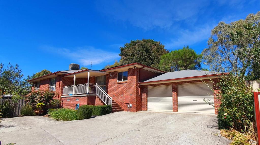 uma casa de tijolos vermelhos com garagem em Ballarat Holiday Homes - Bells Lane - Large Home with Double Garage - Only Minutes from Ballarat CBD - Sleeps 1 to 10 em Ballarat