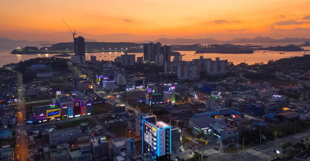 a city skyline at night with a sunset at Jin Arirang Hostel in Yeosu
