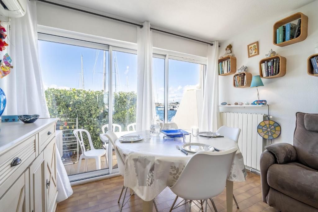 une salle à manger avec une table et une grande fenêtre dans l'établissement Appartement Résidence la Croisette, au Cap d'Agde