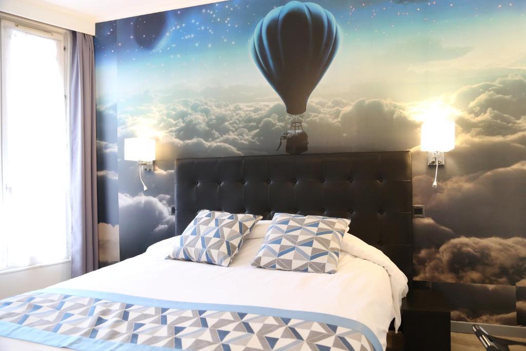 a bedroom with a bed with a balloon in the sky at Hôtel Princesse Isabelle in Puteaux