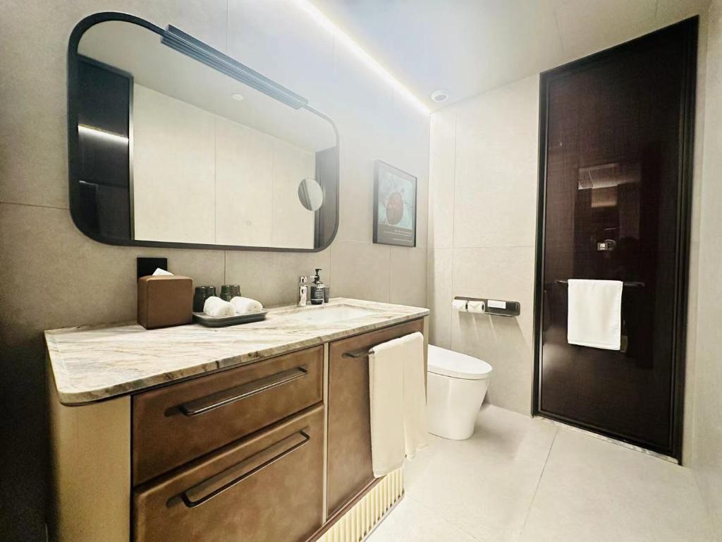 a bathroom with a sink and a toilet and a mirror at IntercityHotel Shanghai Hongqiao Airport - Free Minibar for First Night in Shanghai