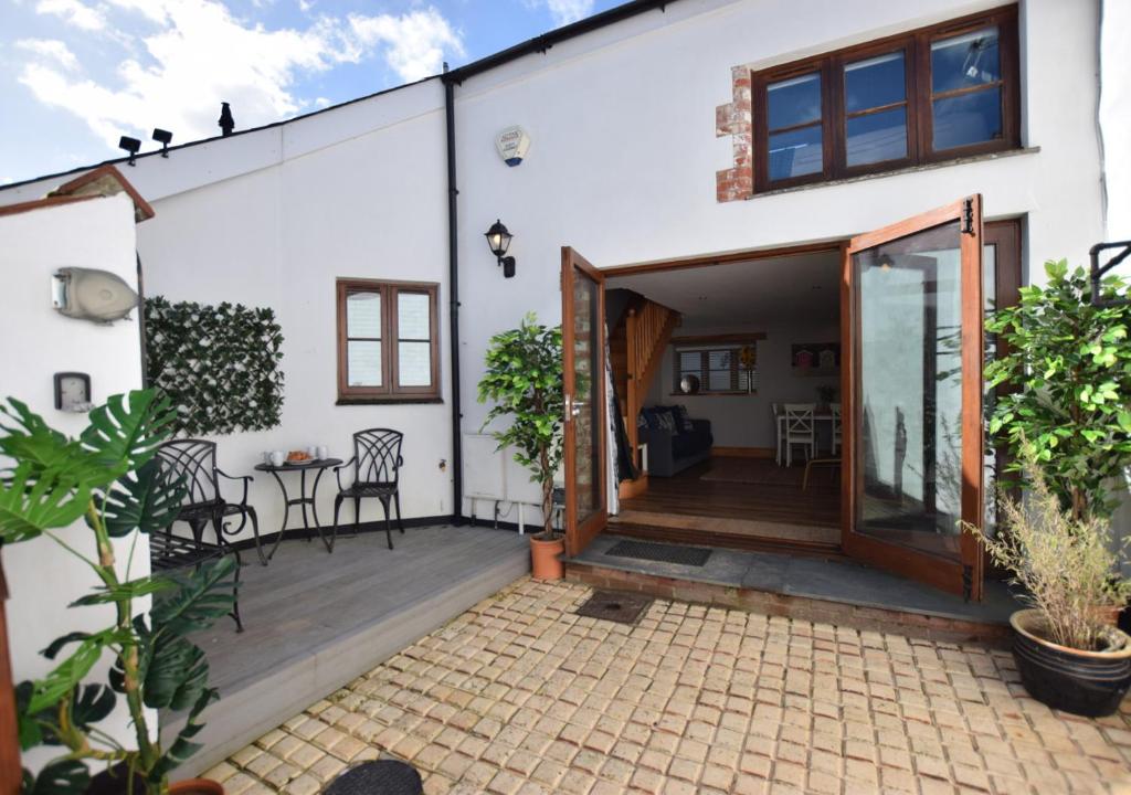 a home with a patio with a table and chairs at The Stables in Braunton