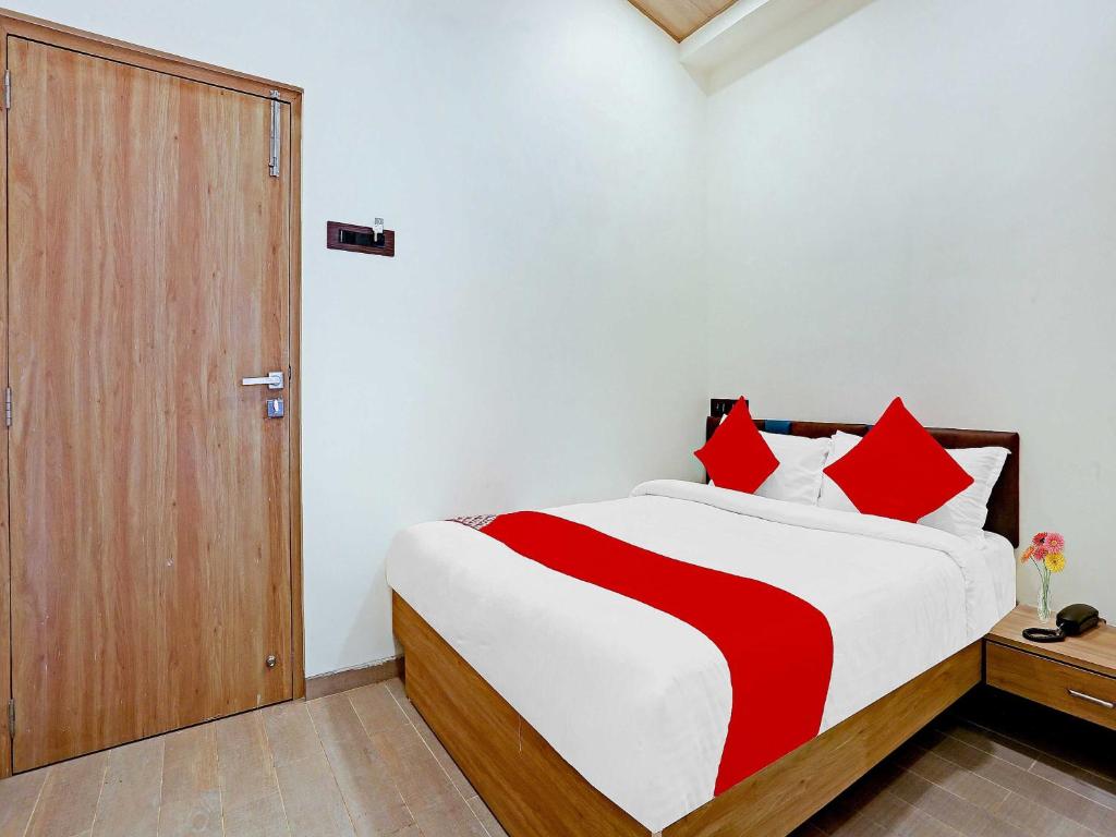 a bedroom with a large bed with red pillows at Malali Residency in Mumbai