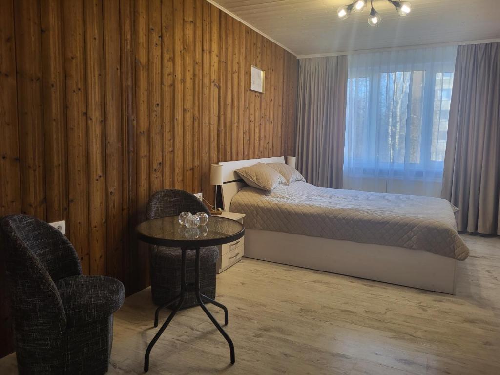 a bedroom with a bed and a table and chairs at Poilsis dviems in Šiauliai