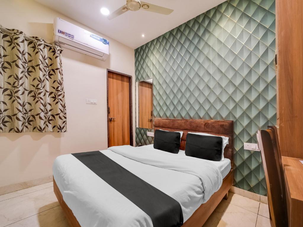 1 dormitorio con cama y pared en Collection O Zamzam Residency en Bhopal