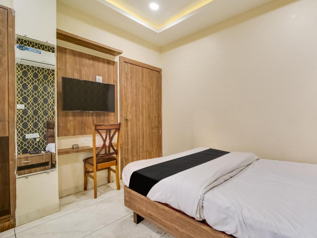 a bedroom with a bed and a desk and a television at Collection O Zamzam Residency in Bhopal
