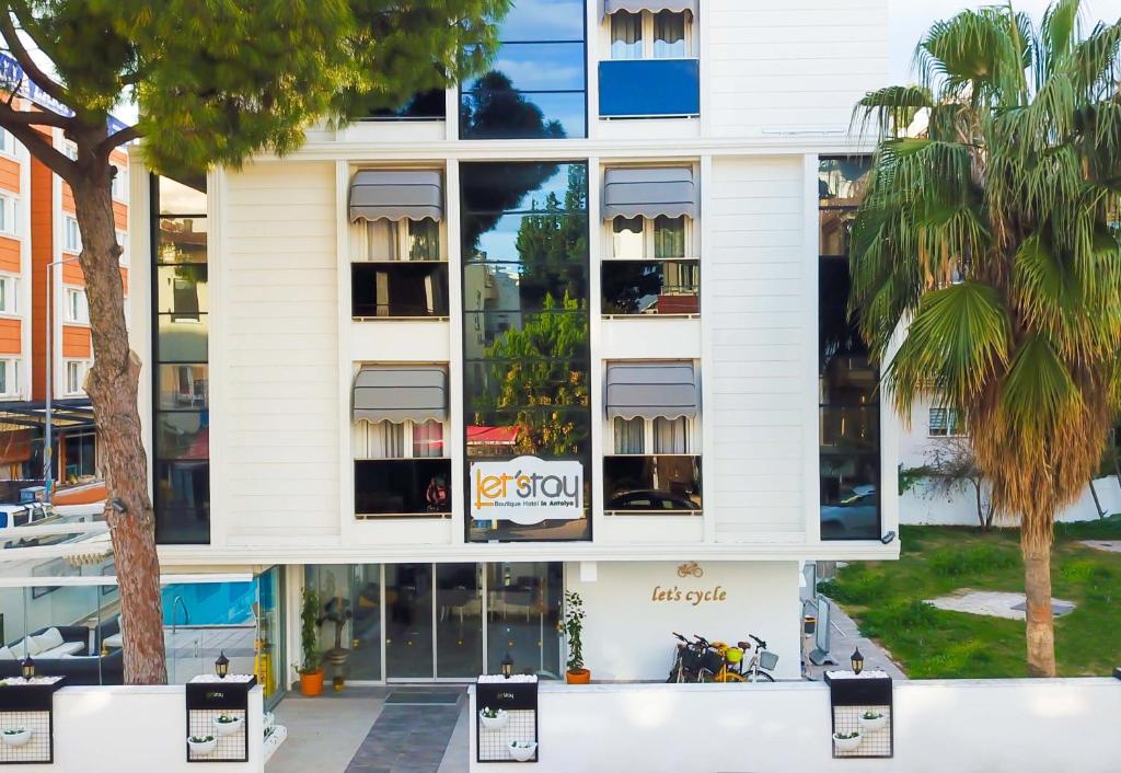 ein Apartmenthaus mit Fenstern und Palmen in der Unterkunft Letstay Hotel - Adults Only in Antalya