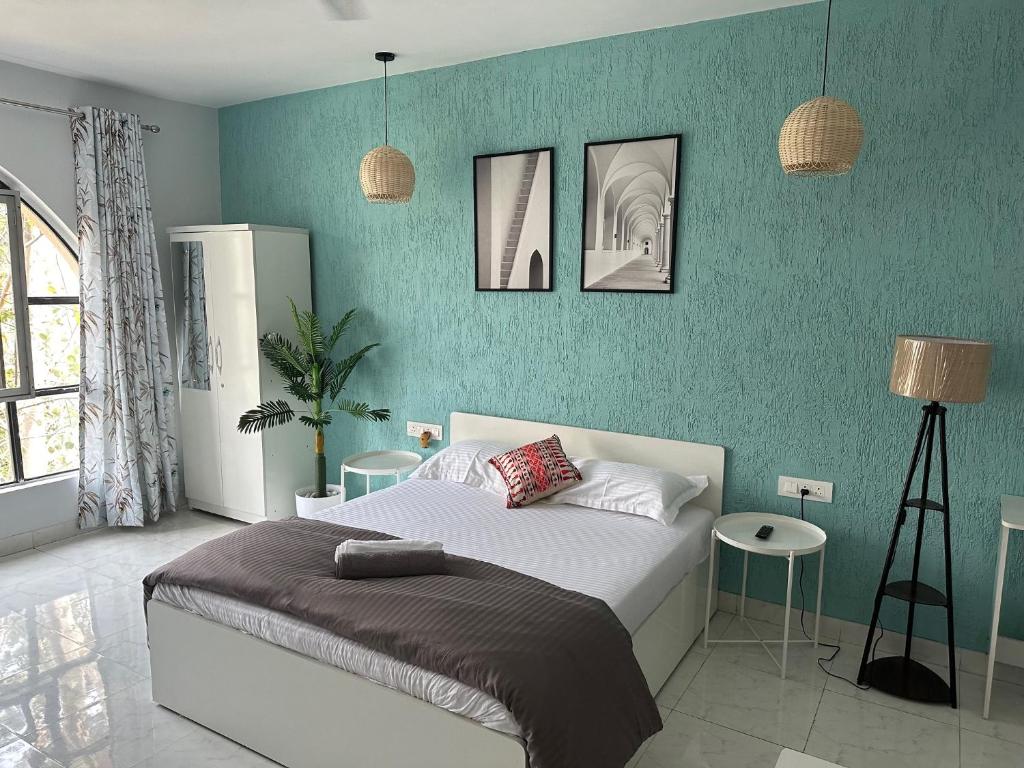 Un dormitorio con una cama y una pared azul. en Azure : Private Studio in Koregaon Park, en Pune