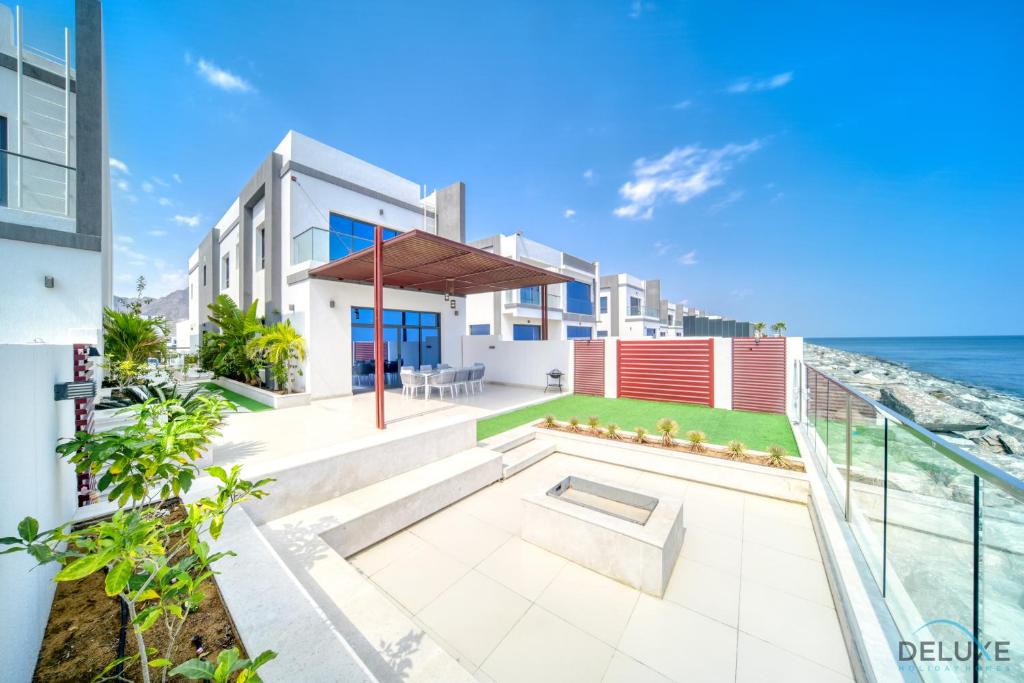 een huis met uitzicht op de oceaan bij Lavish 4BR Villa with 2 Assistant Rooms, Al Dana Island, Fujairah by Deluxe Holiday Homes in Fujairah