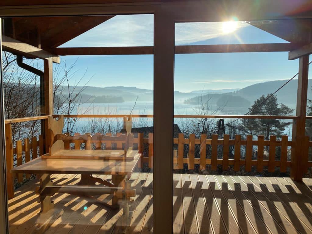 a wooden deck with a table and a view of the mountains at Domekwroznowiepl in Rożnów