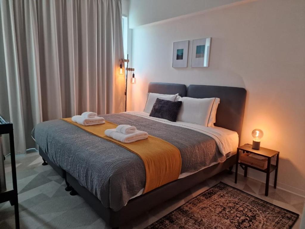 MARTIN Nicosia City Suites في نيقوسيا: غرفة نوم بسرير كبير عليها مناشف
