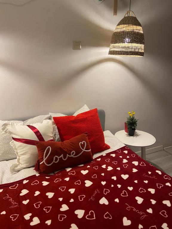 Una cama con una manta roja con corazones. en Nest Apartment en Sopot