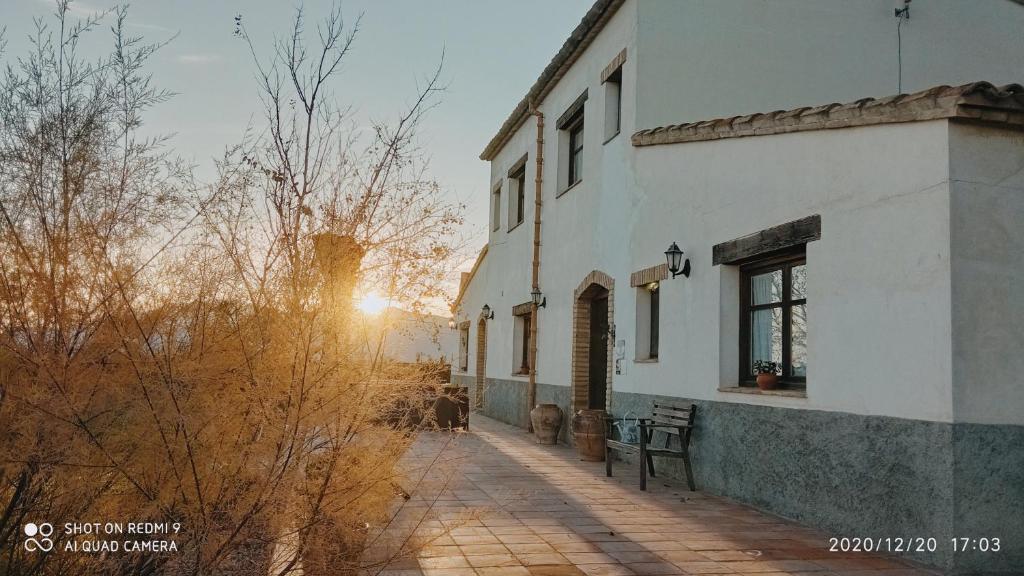 un edificio con la puesta de sol en el fondo en Mas del Tancat en Amposta