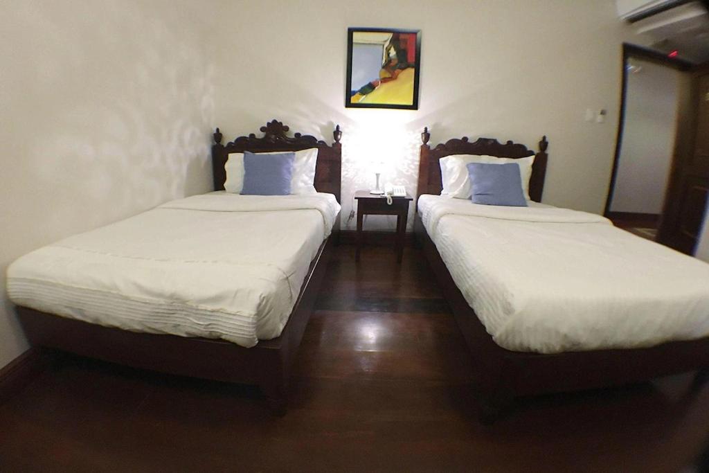 Postel nebo postele na pokoji v ubytování NSCC Hotel Vigan