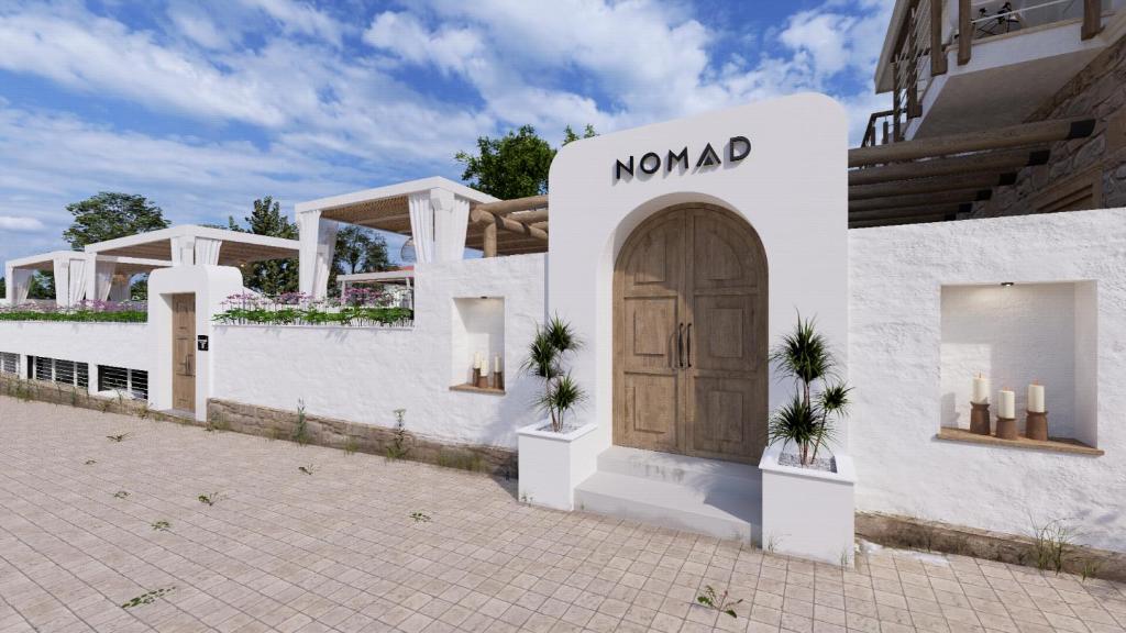 - un bâtiment blanc avec une porte et un panneau dans l'établissement Nomad Boutique Hotel Side - Adults Only, à Sidé