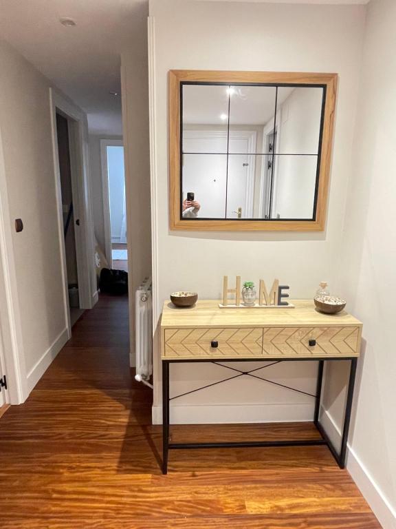 a dressing table with a mirror on a wall at Apartamento Ideal in Mundaka