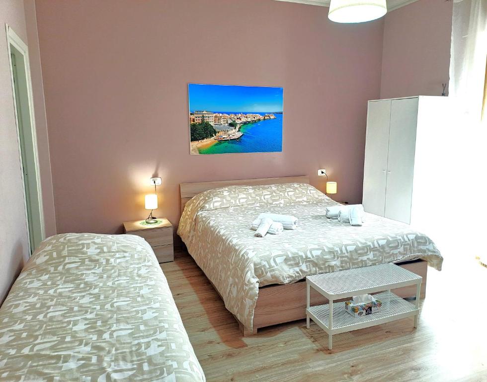 um quarto com duas camas e um quadro na parede em B&B SALLY em Siracusa