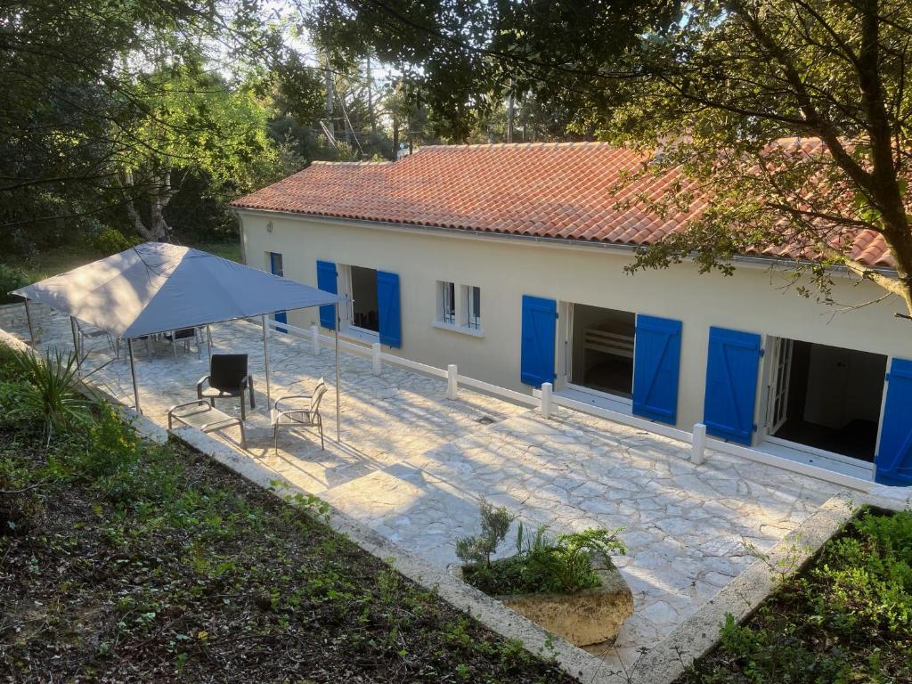 ein weißes Haus mit blauen Türen und einer Terrasse in der Unterkunft Maison 100 m2 plein pied pour 6 personnes 300 m de la plage in Chaucre
