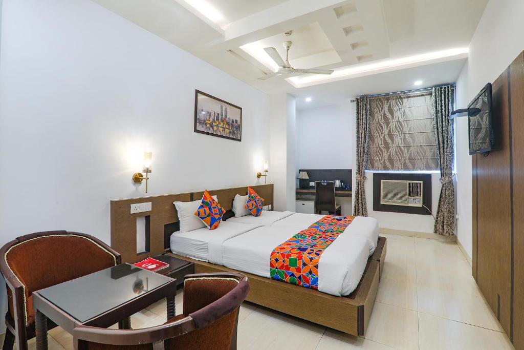 sypialnia z łóżkiem, stołem i biurkiem w obiekcie FabHotel Prime The Continental w mieście Lucknow