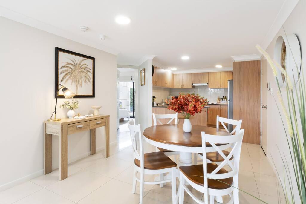 uma cozinha e sala de jantar com mesa e cadeiras em Spacious 2 Bed/2 Bath Garden Apartment Aircon em Brisbane