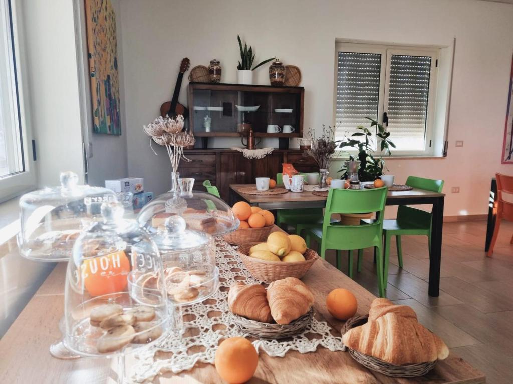 una mesa con un montón de pan y cestas de comida en Agri B&B Terre Joniche, en Isola di Capo Rizzuto
