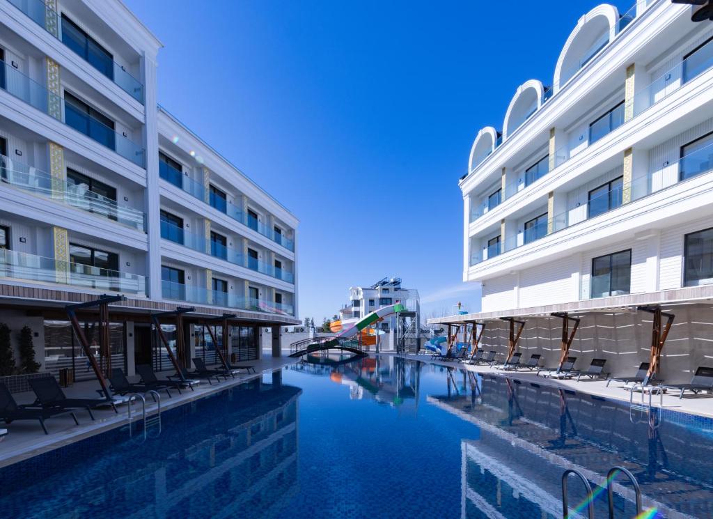 ein Hotel mit einem Pool neben einem Gebäude in der Unterkunft Belenli Resort Hotel in Belek