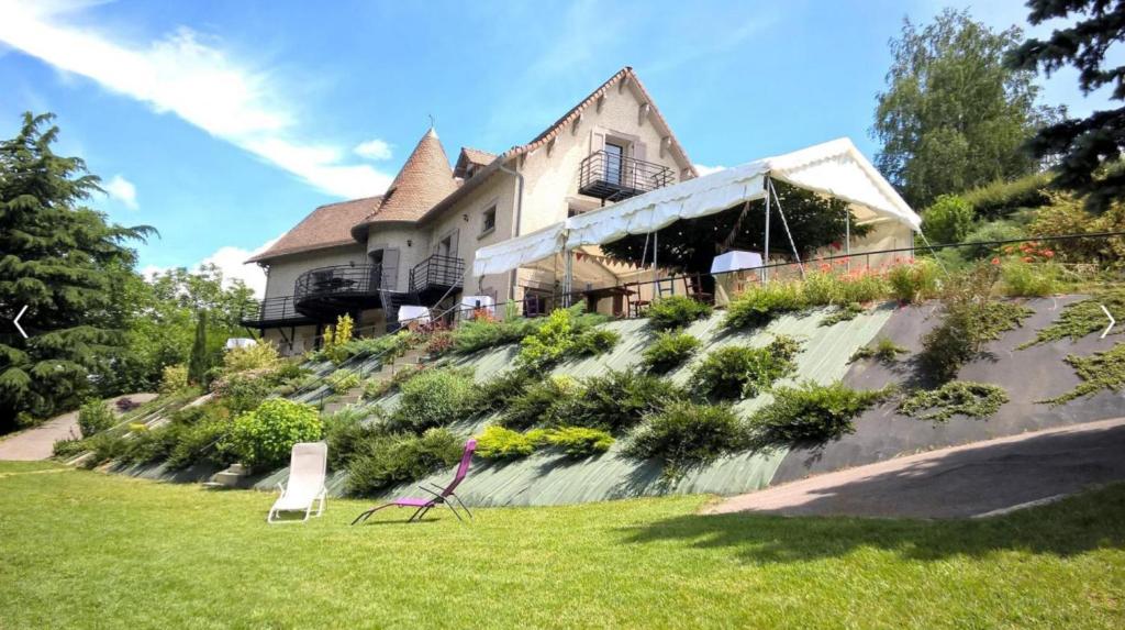 uma casa sentada no topo de uma colina em Le gite de la tour em Bressieux