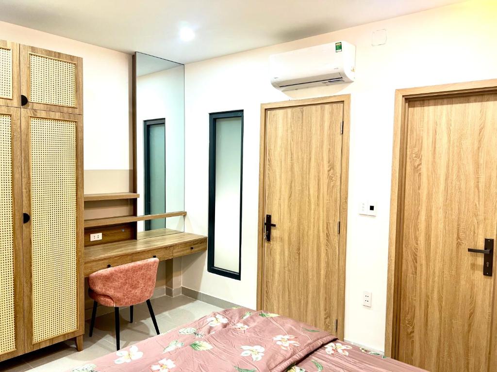 een slaapkamer met een bureau en een bed en een bureau bij Cozy House in Ho Chi Minh-stad
