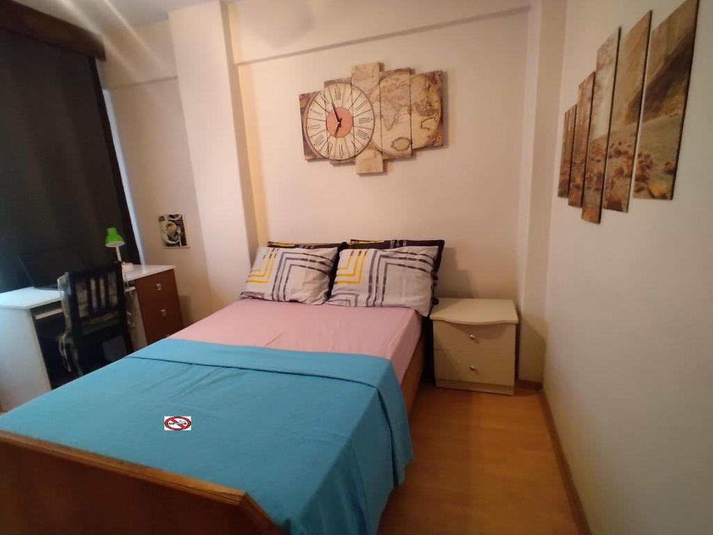 a small bedroom with a bed and a clock on the wall at Feeling at home in İstanbul Center 5 Minutes walk to The Ataköy Metro Station & Metrobus in Istanbul