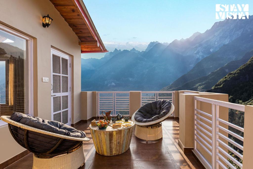 balcón con sillas y vistas a las montañas en StayVista at Bird's Crest Valley Villa, en Rāmgarh