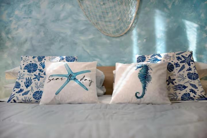 een bed met blauwe en witte kussens met een zeester erop bij Nonna Sere Home in Riva Ligure
