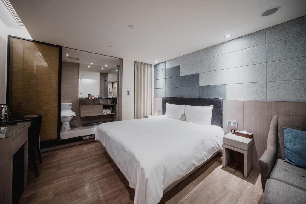 a hotel room with a bed and a couch at Hub Hotel Kaohsiung Yawan Branch in Kaohsiung