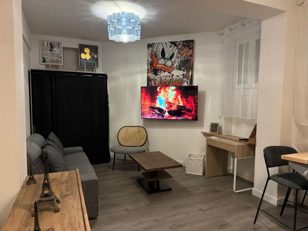 ein Wohnzimmer mit einer Couch und einem Fernseher an der Wand in der Unterkunft Appartement Alfortville proche métro et RER in Alfortville