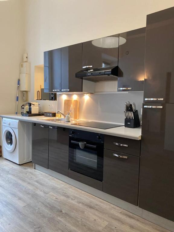a kitchen with a sink and a stove top oven at Le Descartes: cosy in the city centre in Poitiers